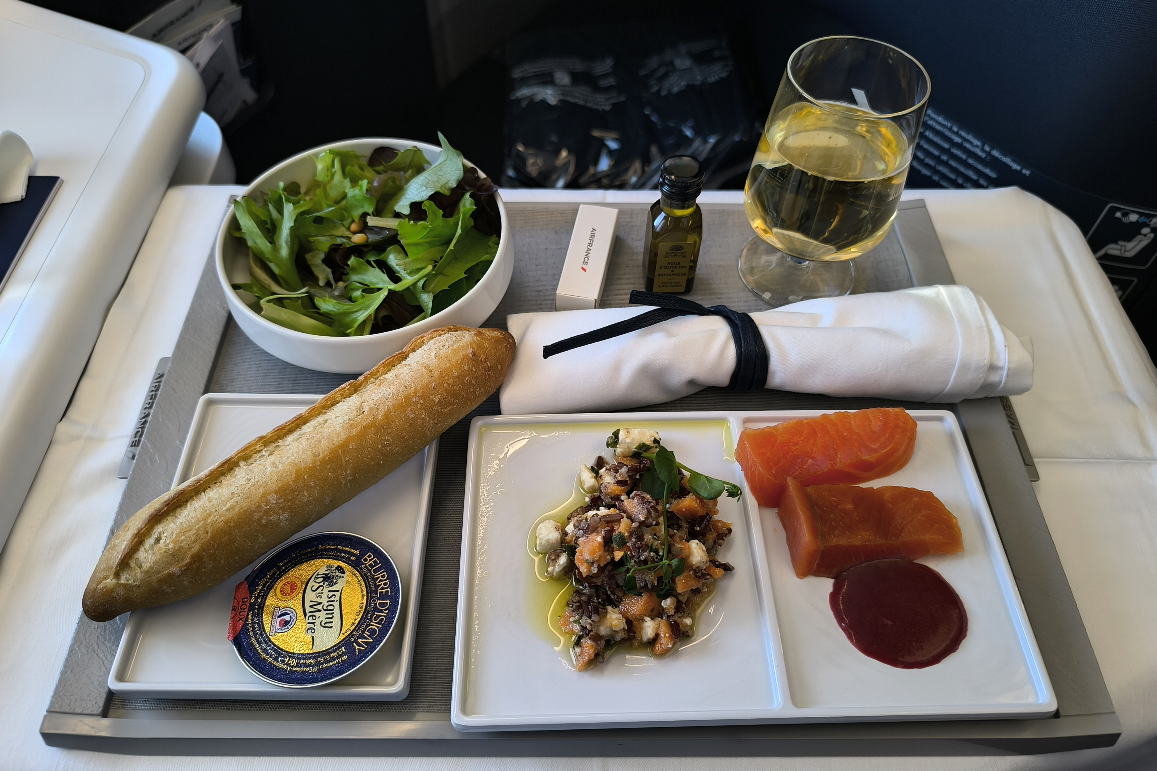 Starter, salad, baguette and white wine served on china in Air France Business aboard an A350