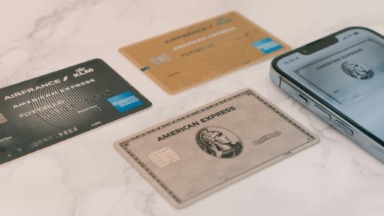 Flying Blue American Express cards beside a regular Amex Platinum card and phone