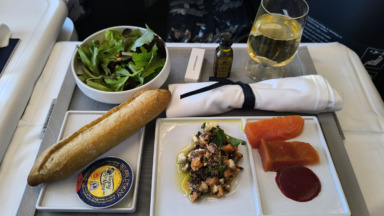 Starter, salad, baguette and white wine served on china in Air France Business aboard an A350